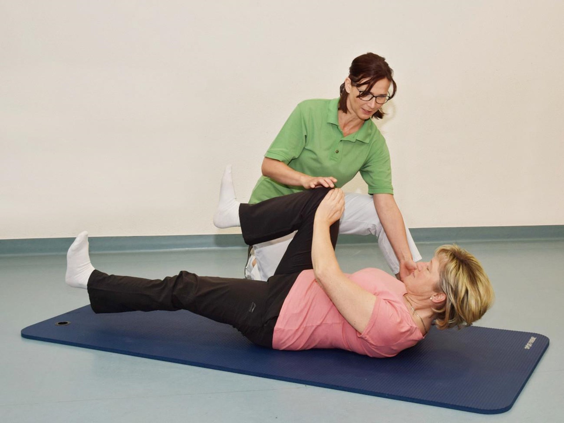 Physiotherapeutin hilft Patientin bei einer Übung